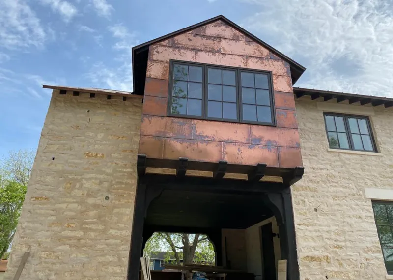 Copper metal panel facade on a stone building for Skylight Installation in Crete
